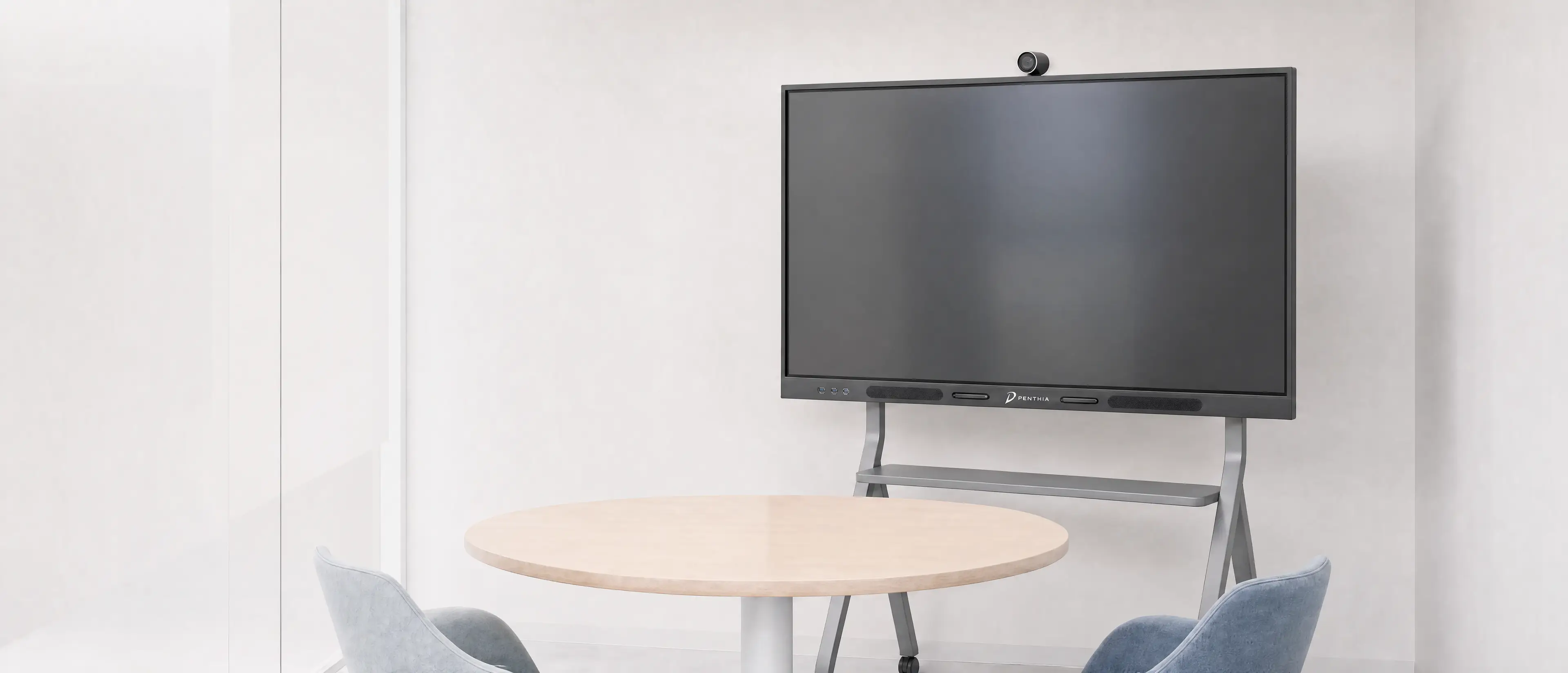 A Penthia display on a gray stand beside a pale table and two chairs
